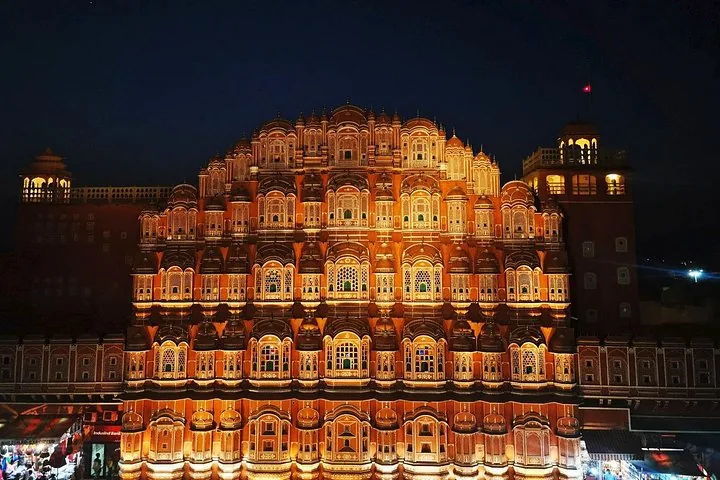 The beautifully illuminated facade of Hawa Mahal at night.