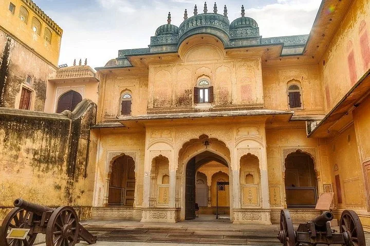 A courtyard with cannons and traditional architecture inside Nahargarh Fort.